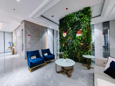 a lobby with a large green wall with blue chairs and tables at 1BR Condotel Suite at Sunshine100 City Plaza #SS02-1 in Manila