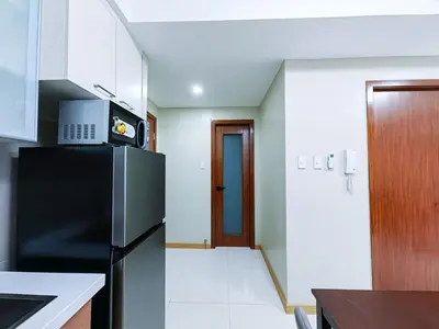 a kitchen with a black refrigerator and a door at 1BR Condotel Suite at Sunshine100 City Plaza #SS02-1 in Manila
