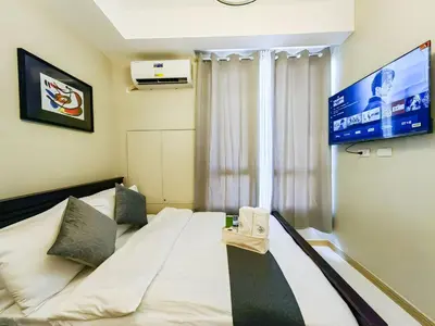 a hotel room with a bed and a tv at 1BR Condotel Suite at Sunshine100 City Plaza #SS03-1 in Manila