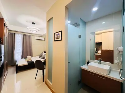a bathroom with a sink and a bed in a room at 1BR Condotel Suite at Sunshine100 City Plaza #SS04-1 in Manila