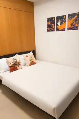 a white bed with two pillows on top of it at Very Spacious Condo at Mall of Asia in Manila
