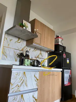 a kitchen with wooden cabinets and a black refrigerator at Azure staycation by scarlet suites in Manila