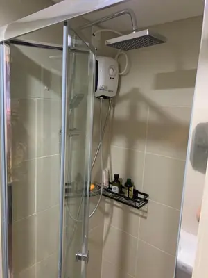 a shower with a glass door in a bathroom at Fame Tower 2 Luxury Queen with own Washer in Manila