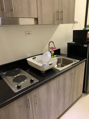 a kitchen counter with a sink and a stove at Fame Tower 2 Luxury Queen with own Washer in Manila
