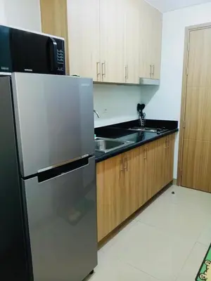 a kitchen with a stainless steel refrigerator and a sink at S Suite Home MOA Staycation in Manila