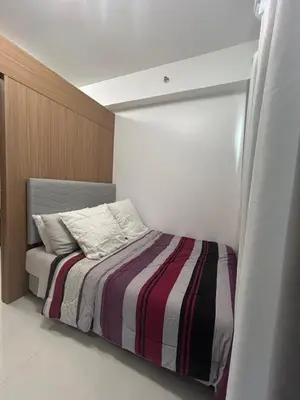 a bedroom with a bed with a striped blanket at Lush Residences 1Br Haven Suite Makati Smart TV Netflix Hi speed internet in Manila
