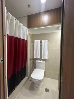 a bathroom with a toilet and a red and white shower curtain at Lush Residences 1Br Haven Suite Makati Smart TV Netflix Hi speed internet in Manila