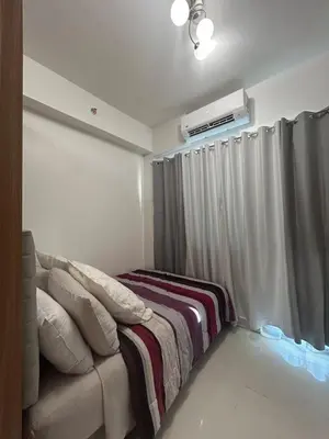 a bedroom with a couch and a window with a air conditioner at Lush Residences 1Br Haven Suite Makati Smart TV Netflix Hi speed internet in Manila