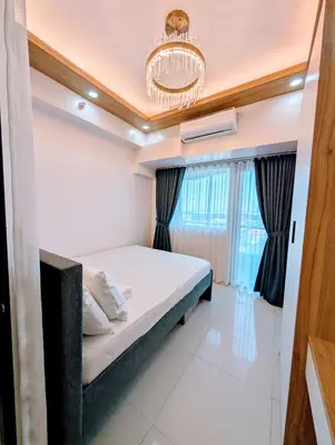 a bedroom with a bed and a chandelier at Cozy Modern Sunset View in Manila