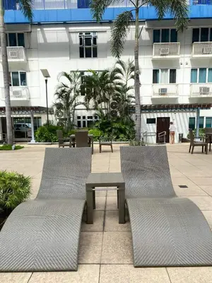 two chairs and a table in front of a building at Sarah's Staycation at Sea Residences Near Moa in Manila