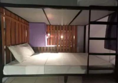 a bedroom with a large white bed with a window at Sean Lojed Hostel in Manila