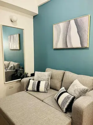a living room with a couch and a mirror at Cedrosa Lofts GA Tower in Manila