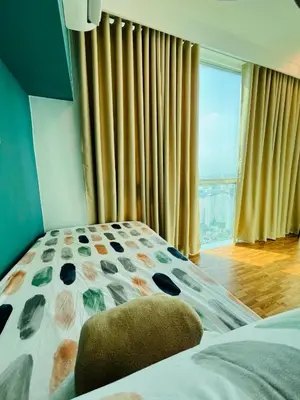 a bedroom with a bed and a large window at Cedrosa Lofts GA Tower in Manila