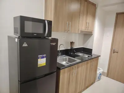 a kitchen with a microwave and a refrigerator and a sink at Shore 3 Tower 30372 in Manila
