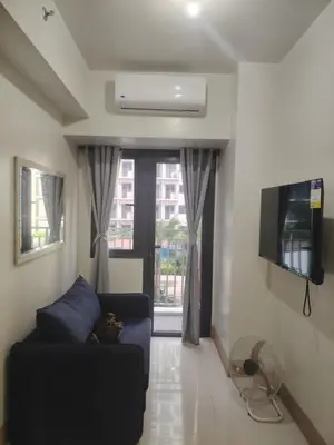 a living room with a couch and a tv at Shore 3 Tower 30372 in Manila