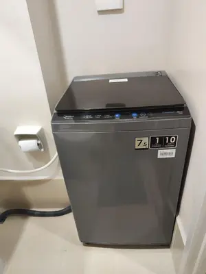 a washing machine in a bathroom next to a toilet at Sweet, Simple and Stylish Studio in Silang