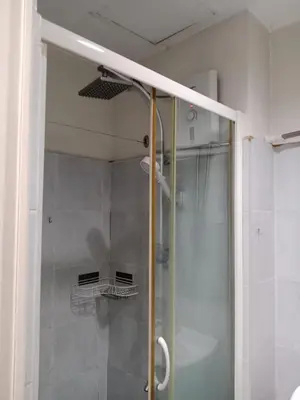 a shower with a glass door in a bathroom at Sea Residence Tower EF Lets in Manila