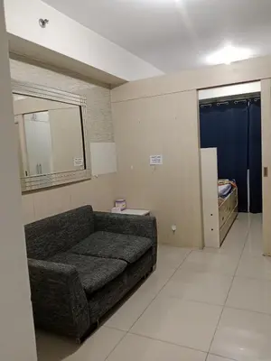 a living room with a couch and a bedroom at Sea Residence Tower EF Lets in Manila