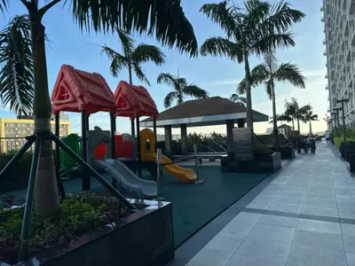 a playground at a resort with slides and palm trees at Coastresidences by Rinseiki in Manila
