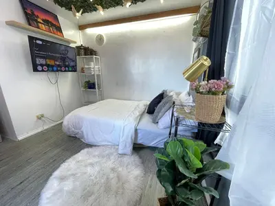 a small room with a bed and a white rug at Stylish unit in Ortigas near podium & holiday inn in Manila