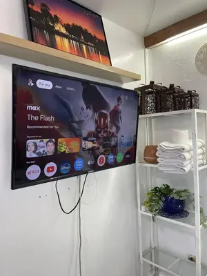 a tv hanging on a wall in a refrigerator at Stylish unit in Ortigas near podium & holiday inn in Manila