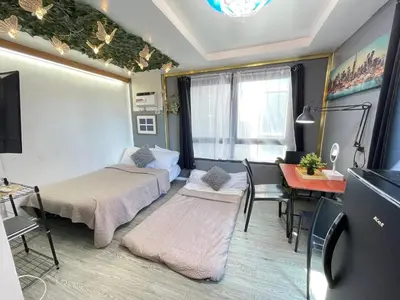 a small room with two beds and a table at Stylish unit in Ortigas near podium & holiday inn in Manila