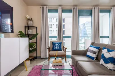 a living room with a couch and a glass table at One Uptown Residence BGC 2BR Cor unit with balcony ,washer in Manila