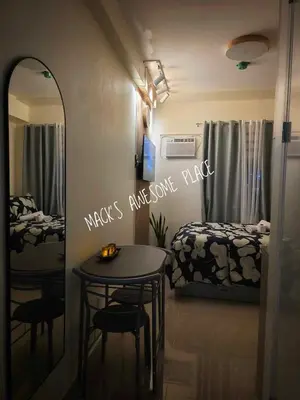 a bedroom with a table and a bed and a mirror at CUBAO Macks Awesome Place NETFLIX UNLIFAST WIFI in Manila