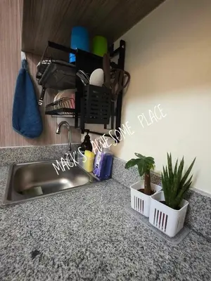 a kitchen counter with a sink and some plants at CUBAO Macks Awesome Place NETFLIX UNLIFAST WIFI in Manila