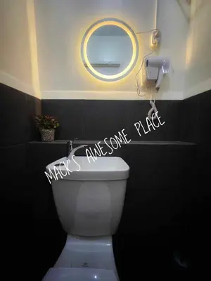 a bathroom with a mirror and a white toilet at CUBAO Macks Awesome Place NETFLIX UNLIFAST WIFI in Manila