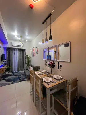 a dining room and living room with a table and chairs at Shore3 Residences Tower2 Staycation in Manila