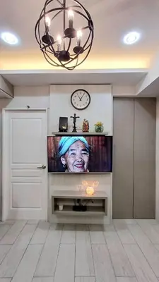a living room with a television with a woman on it at 2 BR, 2 Full Bathrooms, with hotel feels and a jet tub in Manila