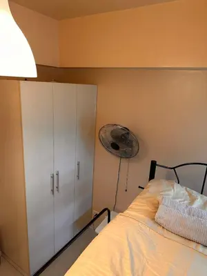 a bedroom with a bed and a closet and a fan at The Essential 2 BR at Sm Jazz makati 100 mbps in Manila