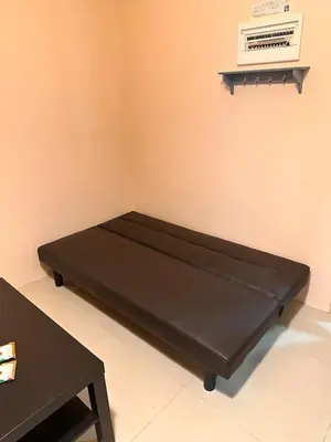 a black bed in a room with a table at The Essential 2 BR at Sm Jazz makati 100 mbps in Manila
