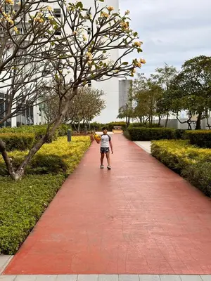 a young boy walking down a red brick sidewalk at The Essential 2 BR at Sm Jazz makati 100 mbps in Manila