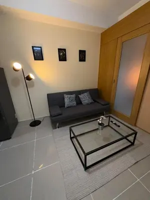 a living room with a couch and a glass coffee table at Spacious pool view at Mall of Asia 100mb Netflix in Manila