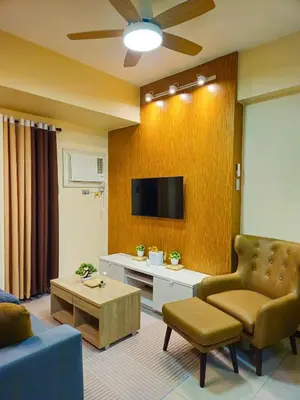 a living room with a couch and a tv at Galini Suites in Manila