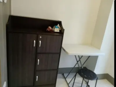a wooden cabinet with a desk and a chair in a room at One Bedroom Unit in Fame Residences in Manila