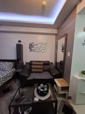 a living room with a couch and a table at QUINS STAYCATION One Bedroom at SMDC South Residences in Manila