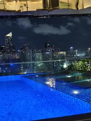a view of a city skyline from a swimming pool at night at Gramercy Residences Makati by Christine Suites PH with Balcony in Manila