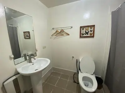 a white bathroom with a sink and a toilet at BGC condo for rent in taguig in Manila