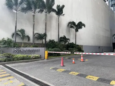 a parking lot with orange cones in front of a building at BGC condo for rent in taguig in Manila