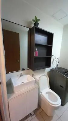 a bathroom with a sink and a toilet and a mirror at Cozy and Luxurious Condominium in Manila