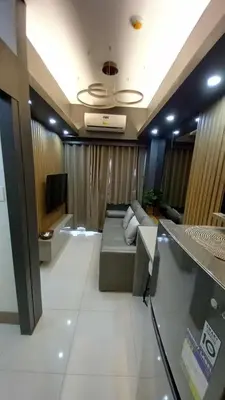 a living room with a couch and a tv at Cozy and Luxurious Condominium in Manila