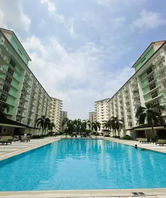 a large swimming pool in the middle of two buildings at Cozy and Luxurious Condominium in Manila