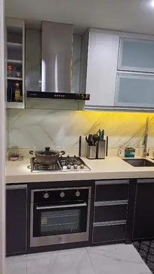 a kitchen with a stove and a sink at 1 Master BR with full bathroom and JET TUB plus 2nd BR with full bathroom Elegant fully furnished with hotel feels in Manila