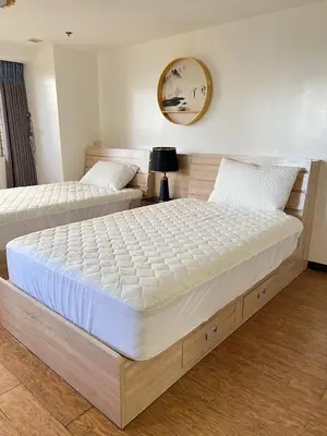two beds in a room with a large mattress at R&R Entire Rental Unit in Manila