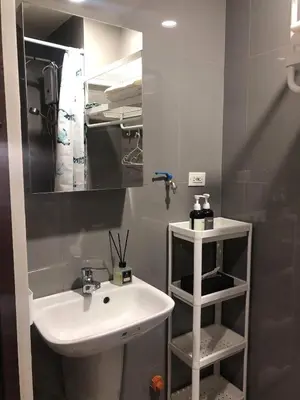 a bathroom with a sink and a mirror at AIR Residences Makati Holiday Home in Manila