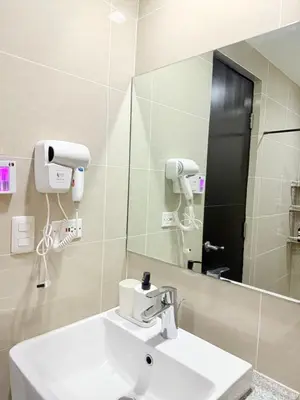 a bathroom with a sink and a mirror at Relaxing and Comfy in Manila