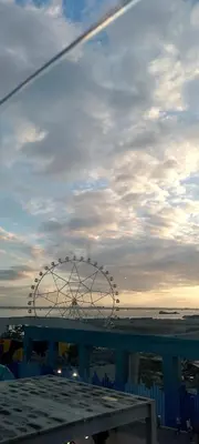 a ferris wheel on the beach under a cloudy sky at Shell Residence in Manila